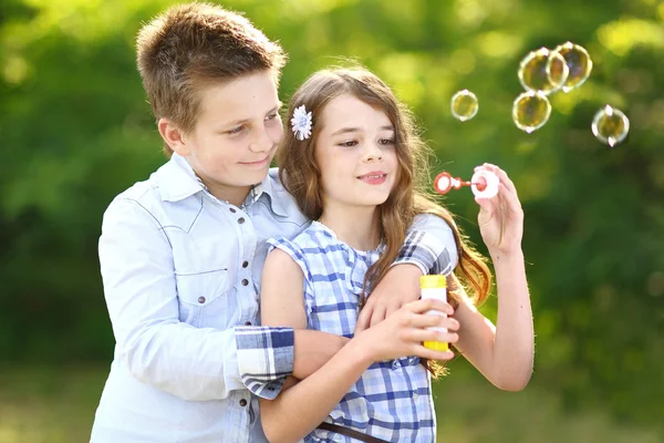 Portrét dívky chlapce v létě s bublinou — Stock fotografie