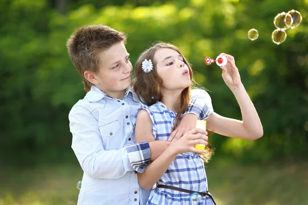 Portrét dívky chlapce v létě s bublinou — Stock fotografie