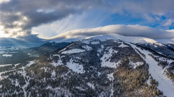 Güneşli ve bulutsuz bir günde karla kaplı güzel kış dağ yamaçlarının havadan görünüşü. Avrupa Kayak Merkezi Güzellik Konsepti