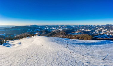 Güneşli ve dondurucu bir günde Avrupa 'da bir kayak merkezinde güzel karlı yamaçların büyüleyici kış manzarası. Kışın aktif dinlenme kavramı