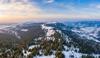 Bulutlu bir günde, bir kış dağ ormanının mistik manzarasının havadan görünüşü. Kuzey ülkelerinin acımasız güzelliği kavramı. Kopyalama alanı