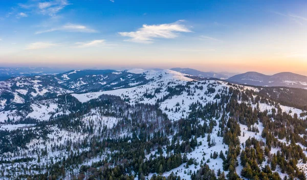 Aerial view of the mystical landscape of a winter mountain forest on a cloudy frosty day. The concept of the harsh beauty of the Nordic countries. Copyspace