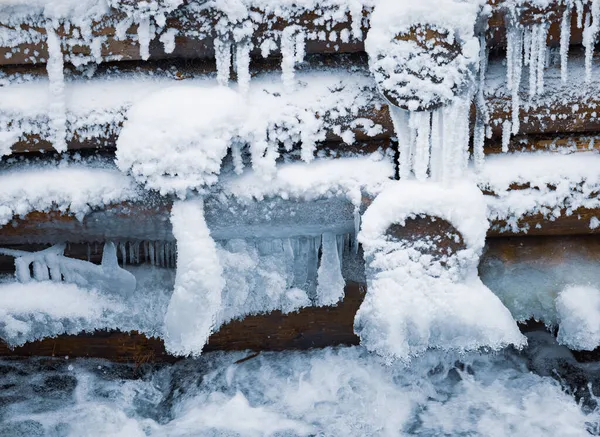 Versterking van stammen, houten muur onder sneeuw in de winter — Stockfoto