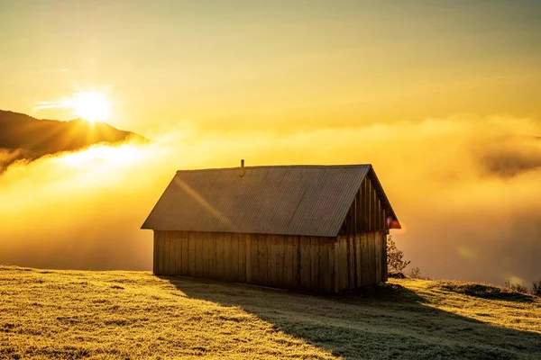 Una casa solitaria se encuentra en un claro en el fondo de un hermoso cielo y niebla blanca —  Fotos de Stock