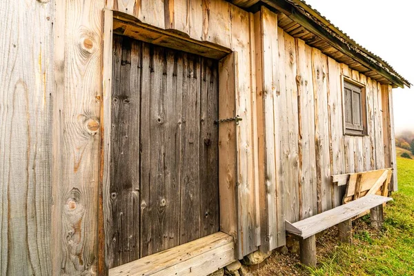 Pequena janela fechada na parede de madeira de uma casa velha — Fotografia de Stock