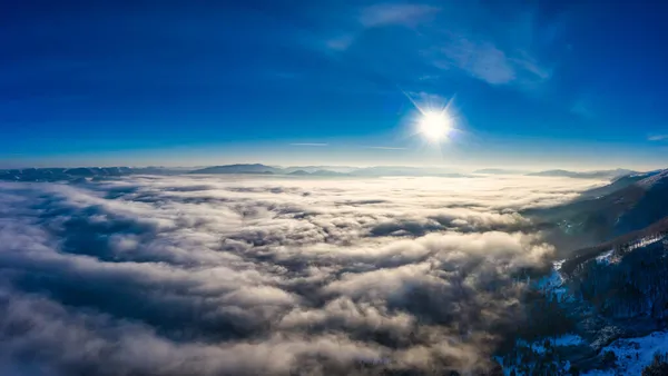 Vol à travers le ciel du soir avec nuages sur la montagne — Photo