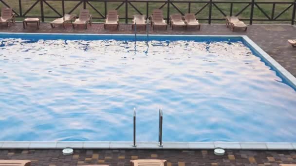 Top uitzicht op het zwembad met helder water op vakantie op zonsondergang achtergrond — Stockvideo
