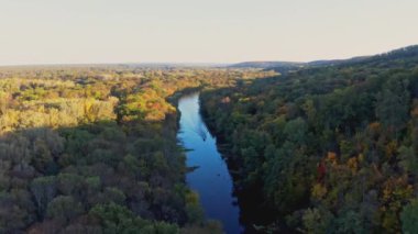 Sürat teknesi sonbaharda yemyeşil ağaçlar arasında dar bir nehirde yol alır.