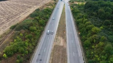 Arabalar ağaçlar arasında uzanan uzun bir patikadan geçiyor.