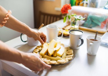 Çay ve kahveyle kahvaltı, meyve parçaları, tereyağlı tost ve fındıklı ekmek...