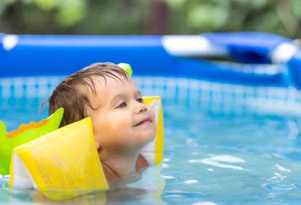 Enfant en survêtement nage dans la piscine dans la cour — Photo
