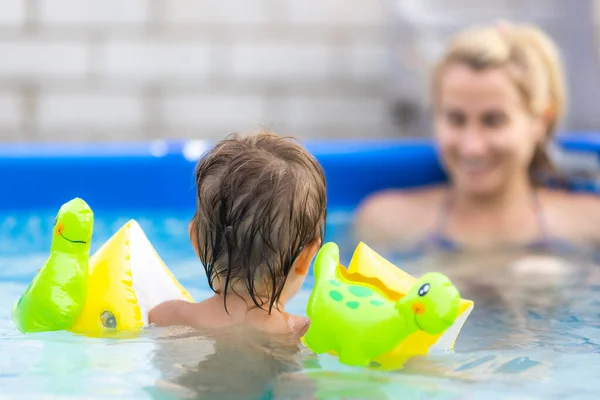 Mamá juega con un bebé desnudo en exceso en la piscina sobre el fondo de un atardecer de verano —  Fotos de Stock