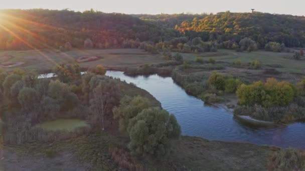 Vista panorámica del río curvilíneo entre los prados al atardecer en otoño — Vídeos de Stock