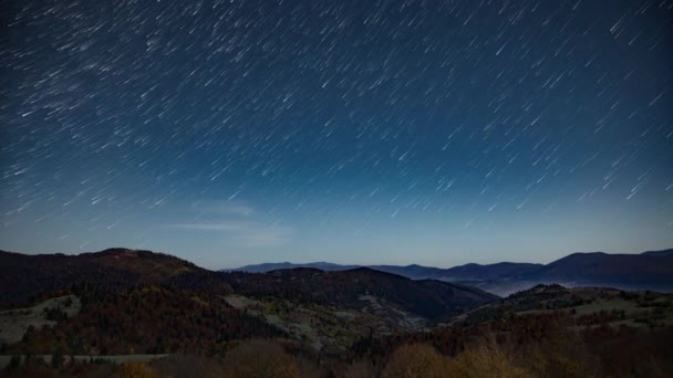 Nära stjärnhimlen ovanför skogsberg och kullar i skymningen — Stockvideo