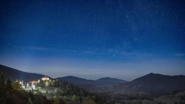 Starry sky with white clouds floating above town in highland — 图库视频影像