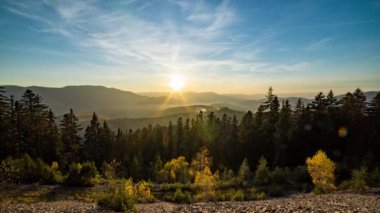 Gün batımından gün batımına kadar tepeler boyunca dağlık arazide kozalaklı ormanlar.