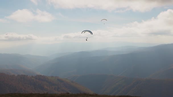 Parapente deporte activo contra montañas gigantes en las tierras altas — Vídeo de stock