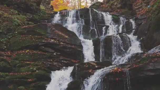 Vattenfall faller nerför bergssluttningen i höstskogen — Stockvideo