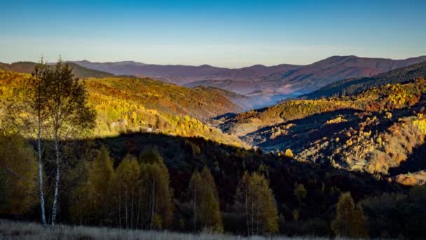 El sol ilumina las tierras altas con montañas y colinas en la mañana — Vídeos de Stock