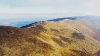 Mavi bulutlu gökyüzünün altındaki dağ sırtında dar yollar