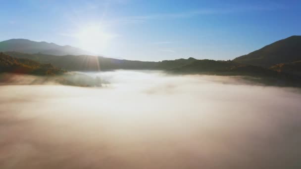 La luz del amanecer entre las nubes sobre el cañón montañoso en la niebla — Vídeos de Stock