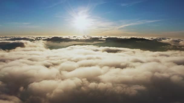 Zon schijnt helder boven witte pluizige wolken bij zonsopgang — Stockvideo