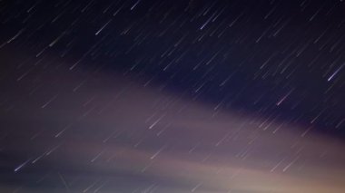 Gece yıldızlı gökyüzü alacakaranlıkta süzülen açık pembe bulutlarla