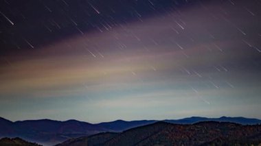 Gece yıldızlı gökyüzü alacakaranlıkta süzülen açık pembe bulutlarla