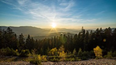 Gün batımından gün batımına kadar tepeler boyunca dağlık arazide kozalaklı ormanlar.