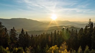 Gün batımından gün batımına kadar tepeler boyunca dağlık arazide kozalaklı ormanlar.