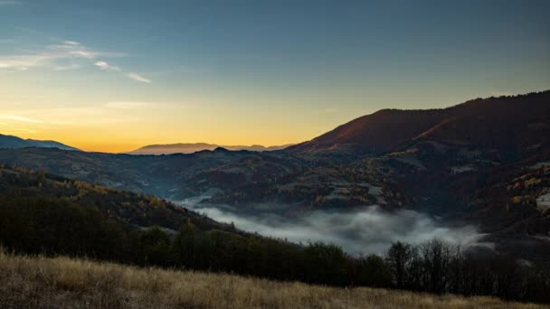 Il sole sorge in altopiano e la nebbia mattutina riempie la valle in autunno — Video Stock