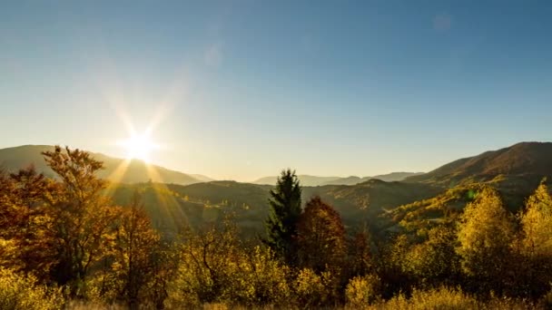 Brillante sol sale de detrás de montañas lejanas en las tierras altas — Vídeos de Stock