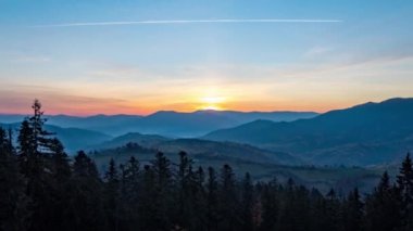 Gün batımından gün batımına kadar tepeler boyunca dağlık arazide kozalaklı ormanlar.