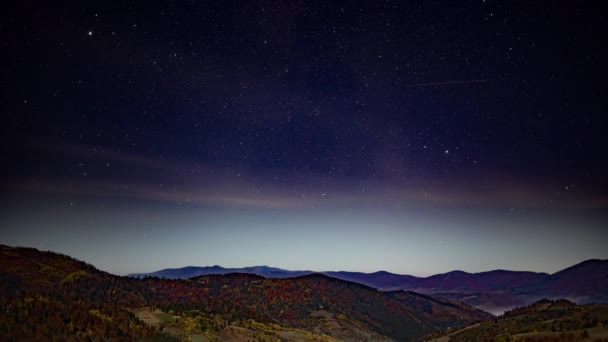 Ночное звездное небо с розовыми облаками над высокогорьем осенью — стоковое видео