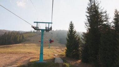 Bir adam sonbaharda kayak asansörüne biner.