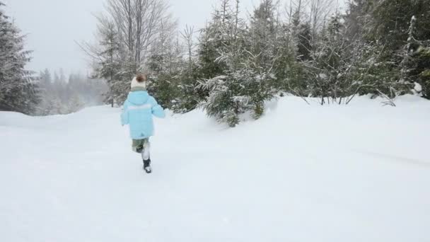 Happy kids running on snowy spruce forest. — Stock Video