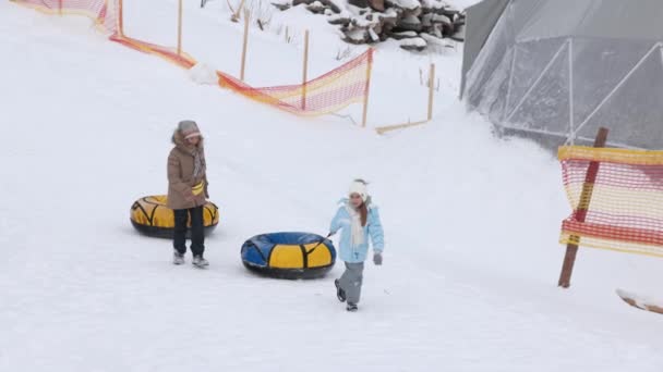 年轻姑娘们骑在雪道上下山. — 图库视频影像