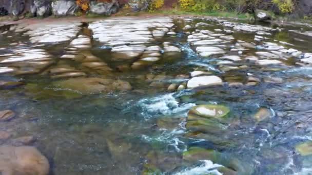 Flacher Gebirgsfluss am Fuße des Berges mit Terrakottawäldern — Stockvideo