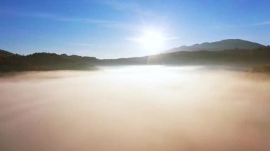 Güneşin doğuşu bulutların arasında, dağlık kanyonun üzerinde sisli