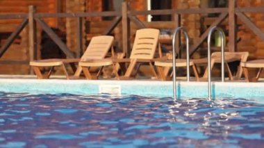 Günbatımı arka planında temiz suyla yüzme havuzunun en üst manzarası