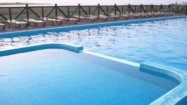 Blick auf das Schwimmbad mit klarem Wasser im Urlaub bei Sonnenuntergang — Stockvideo