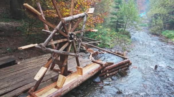 A malom vezeti a vizet a folyóban az őszi erdőben felhős időben — Stock videók