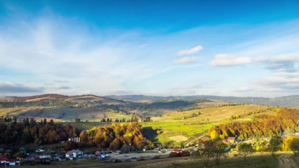 Tájkép a falu épült hegyvidéki völgyben ősszel — Stock videók