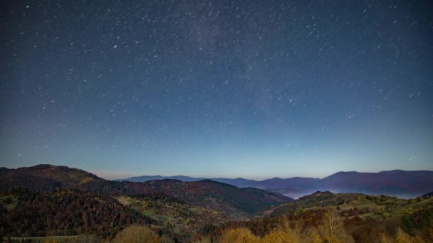 Nära stjärnhimlen ovanför skogsberg och kullar i skymningen — Stockvideo