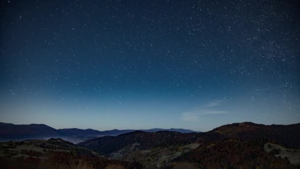 Nächtlicher Sternenhimmel über bewaldeten Bergen und Hügeln in der Abenddämmerung — Stockvideo