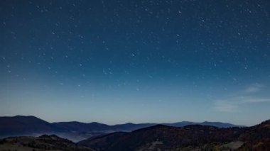 Orman dağlarının ve tepelerin üzerindeki yıldızlı gökyüzüne yakın alacakaranlıkta