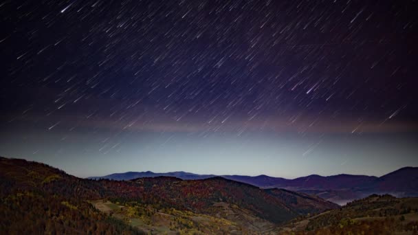 Nocne gwiaździste niebo z różowymi chmurami nad górami jesienią — Wideo stockowe