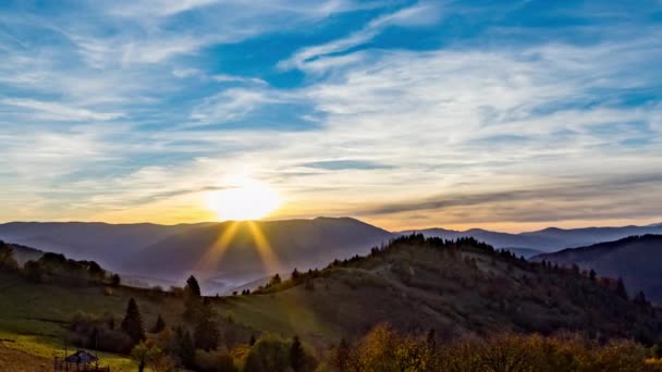 Sole tramonta dietro montagne lontane in altopiano in autunno — Video Stock