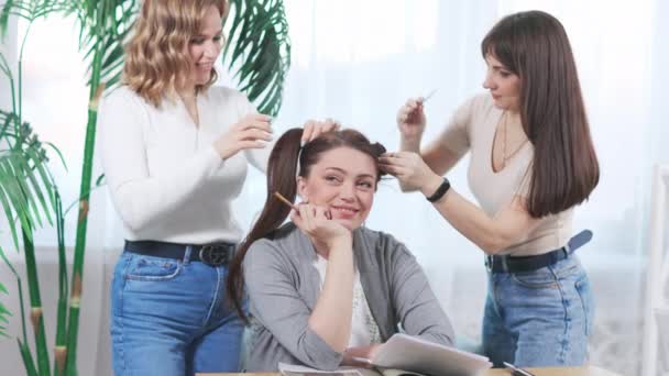 Femmes faisant coiffure drôle à jolie jeune femme. — Video