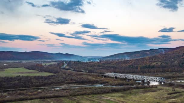 Ponte ferroviária sobre o rio no vale do planalto ao pôr do sol — Vídeo de Stock